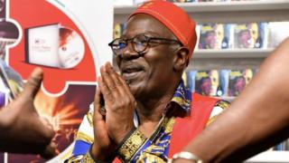 Ivorian reggae singer Seydou Kone, aka Alpha Blondy, gestures as he signs copies of his new album "Human Race" in Abidjan on September 15, 2018.