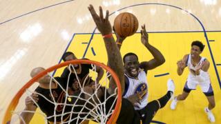 Draymond Green, de los Warriors, intenta anotar ante la oposición de J. R. Smith, de los Cavs.