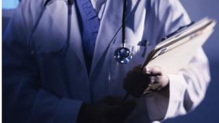 A doctor holding some patient files