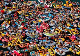 People on inflatable boats enjoy the weather on the Lake Lucerne in Sisikon, Switzerland
