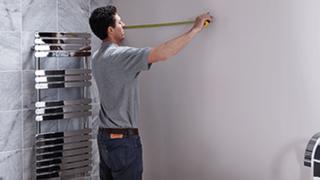 man putting up a rail in a bathroom