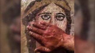 Man's hand covers mouth of mosaic image of female face