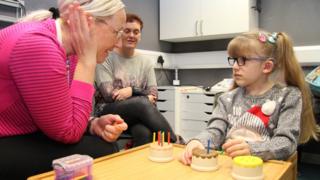 Leia receiving support wearing her hearing implant requiring complex brain surgery