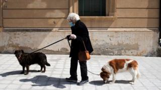 Woman walks her dogs in Locri, Calabria region, southern Italy - 8 April
