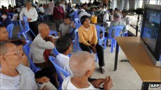 Cambodians watch TV in a cafe