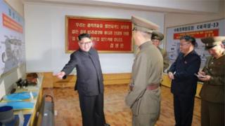 Igicucu cya Kim Jong-un kigaragara ku gishushanyo cya misile izwi nka Hwasong-13 mu gihe abandi bategetsi bakingirije igishushanyo cy'indi misile itererwa mu bwato bugendera mu nsi y'inyanja