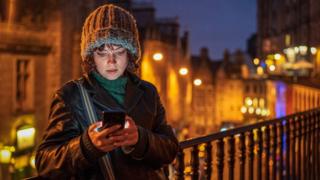 Woman looking at phone in Edinburgh