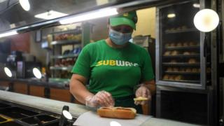 Сотрудник метро делает бутерброд