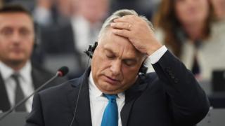 Hungary's Prime Minister Viktor Orban places his hand on his head in an emotive gesture
