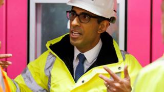 Britain's Prime Minister Rishi Sunak reacts as he tours the Combined Heat and Power Plant (CHP) at King's Cross in London on February 7, 2023.