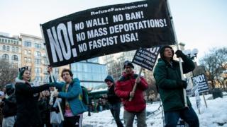 Demonstrators in New York hold up a banner during a protest against President Donald Trump's proposed travel ban, 17 March 2017