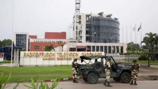 Gabonese soldiers stand in front of the headquarters of the national broadcaster Radiodiffusion Television Gabonaise (RTG) in Libreville