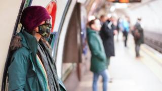 امرأة ترتدي قناعا للوقاية من المرض في محطة للمترو في لندن