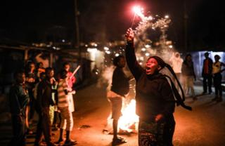A woman holds a sparkler during New Year celebrations in the Kibera slum in Nairobi on January 1, 2019