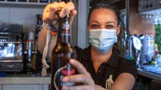A waitress in a socially-distanced bar in Spain
