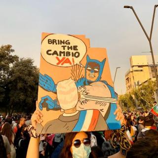 Un hombre sostiene un cartel