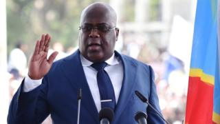 President Felix Tshisekedi raises his hand as as he takes the oath of office on 24 January 2019. at the Palais de la Nation in Kinshasa.