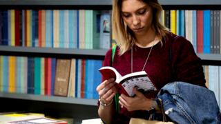 Девушка листает книгу