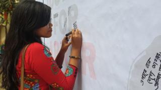 জাস্টিস ফর আবরার লেখা একটি ব্যানারে নানা মন্তব্য লিখছেন একজন বুয়েটের শিক্ষার্থী।