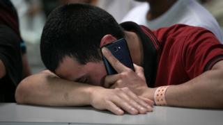 Un joven inmigrante sosteniendo un teléfono celular