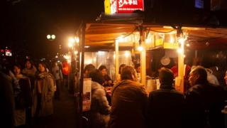 Khách hàng đang lướt qua các yatai nằm dọc bờ kênh quận Nakasu của thành phố Fukuoka