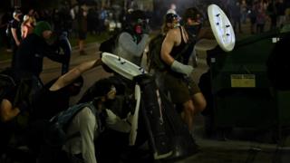 Protesters hold up make-shift shields during unrest in Kenosha