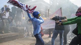 A White Supremacist tries to strike a counter protestor with a White Nationalist flag during clashes at Emancipation Park where the White Nationalists are protesting the removal of the Robert E. Lee monument in Charlottesville, Va., USA on August 12, 2017.