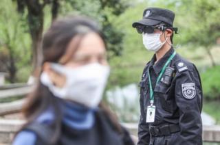 浙江的一个公园里,保安人员用AR(扩增虚拟实境)设备测量公园游客的体温。
