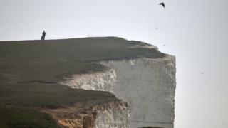 A person walks along Beachy Head, close to Eastbourne, on the south coast of England on Sunday.