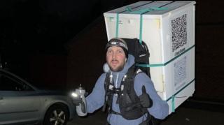 man carrying fridge