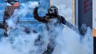 A riot policeman clashes with demonstrators during a protest on 23 February, 2020