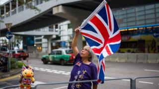 Một người phụ nữ Hong Kong vẫy lá cờ Anh Quốc