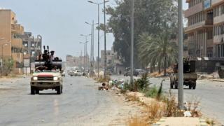 مقاتلون موالون لحكومة الوفاق الوطني الليبية المعترف بها من قبل الأمم المتحدة يركبون في شاحنة على طول طريق في منطقة قصر بن غشير جنوب العاصمة الليبية طرابلس، في 4 يونيو/حزيران 2020