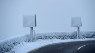 Road signs are covered with snow on the A628 Woodhead Pass in the Longdendale Valley in Derbyshire's High Peak