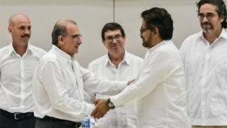 The head of the Colombian government delegation to the peace talks, Humberto de la Calle (L) and the head of the FARC-EP delegation Ivan Marquez (R) shake hands after the signing of the agreement on victims of the conflict at Convention Palace in Havana, on 15 December 2015