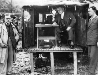 Picture shows outside broadcast van with microphones, equipment and reporters at Loch Lomond in 1932.