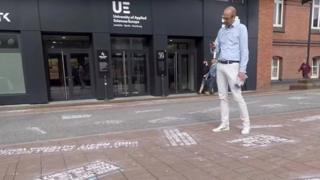 A man takes pictures of "hate tweets", a part of the art project "#HEYTWITTER" created by Shahak Shapira, outside Twitter office in Hamburg, Germany August 4, 2017