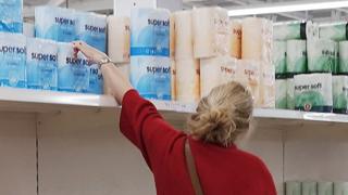 A woman reaches for toilet paper