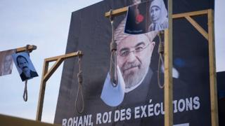 İran Cumhurbaşkanı Hasan Ruhani'nin posterinin önüne temsili idam sehpaları