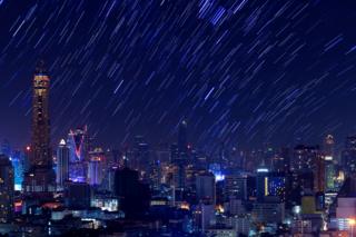 Imagem mostra chuva de meteoros em área cheia de edifícios