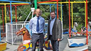 Graeme Watson and Geoffrey Boot MHK in front of the Silverdale Glen carousel
