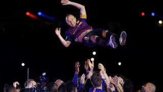 Andres Iniesta is thrown into the air by his Barcelona team-mates