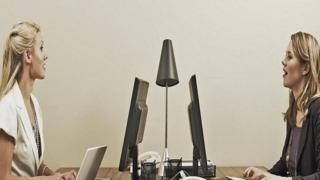 موظفتان تتحدثان معا في مكتب مفتوح