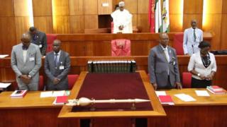 aarẹ̀ asofin agba Bukọla saraki duro pẹlu awọn oṣiṣẹ ile aṣofin agba niwaju ọpa aṣẹ ile