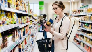 Woman buying pasta in supermarket