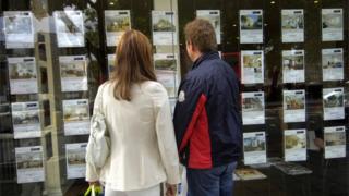 Мужчина и женщина смотрят в окно агентов по недвижимости
