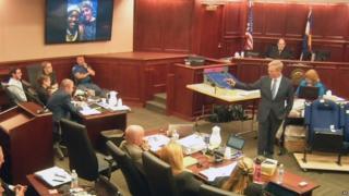 Image taken from video showing James Holmes, left, listening to lead prosecutor George Brauchler