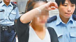 A female tour guide is led away by police - cleared for online use only