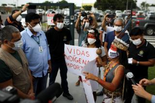 Vanderlecia talks to Robson Santos da Silva, as she takes part in a protest
