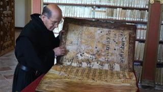 Un monje examina uno de los códices en la biblioteca del monasterio